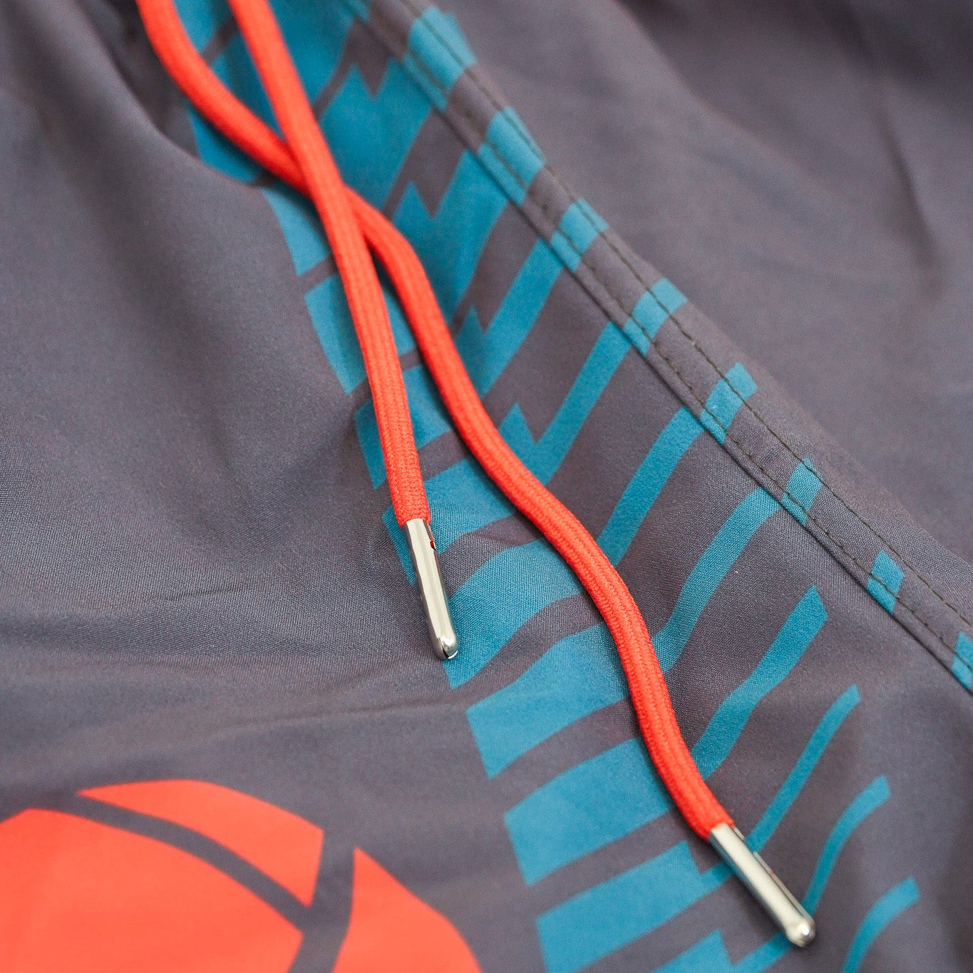 Close-up of a jacket with red and blue accents and a volleyball design.