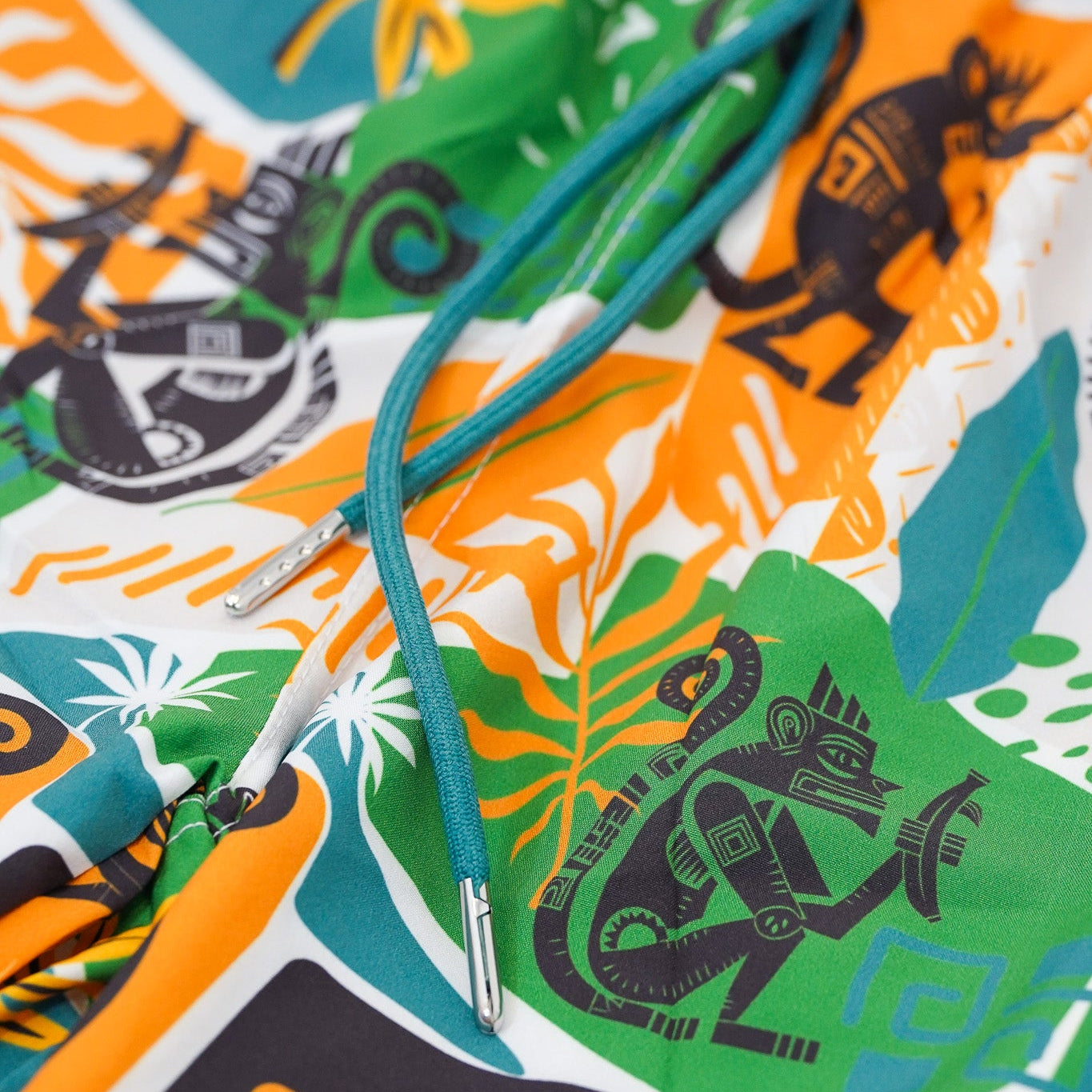 Close-up of a colorful fabric with tribal designs and a green cord