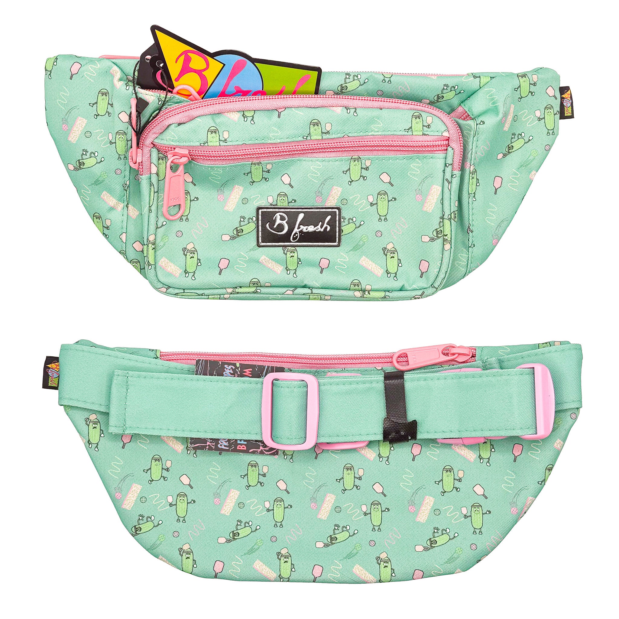 Mint green fanny pack with pink zippers and a pattern of cartoon pickles playing pickleball