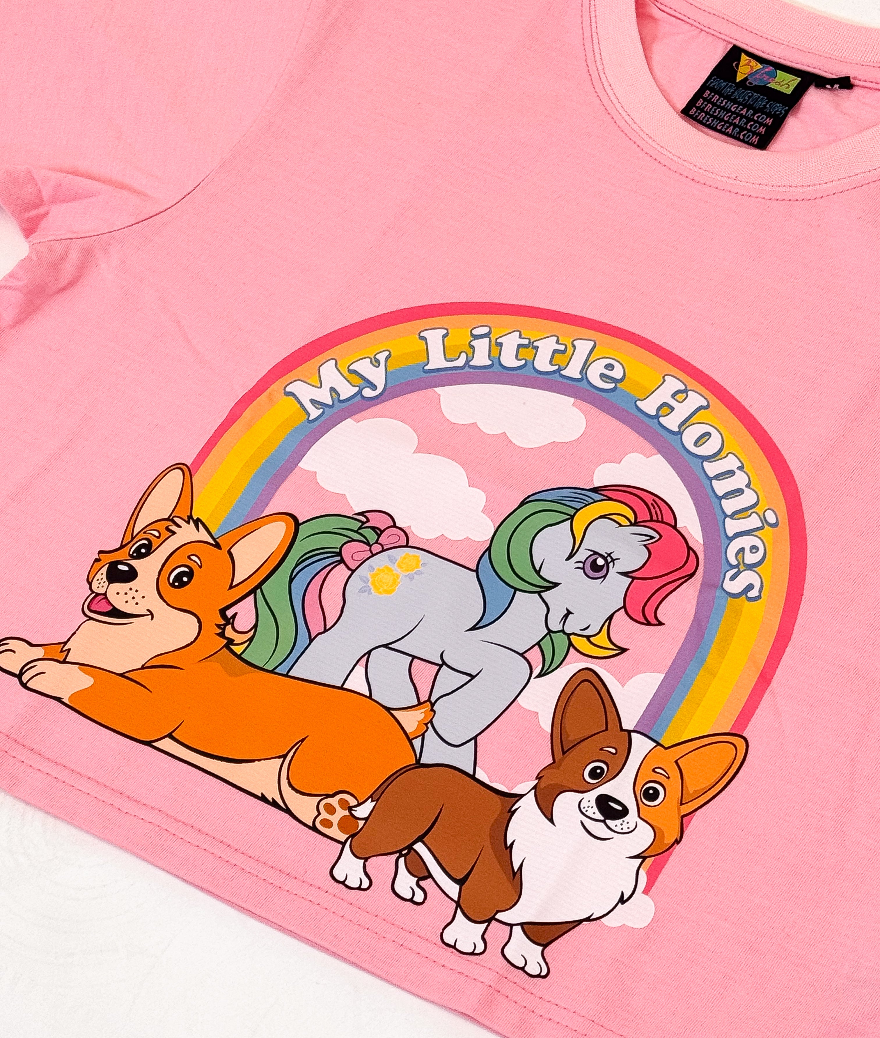 Pink t-shirt with cartoon dogs and a rainbow and clouds design