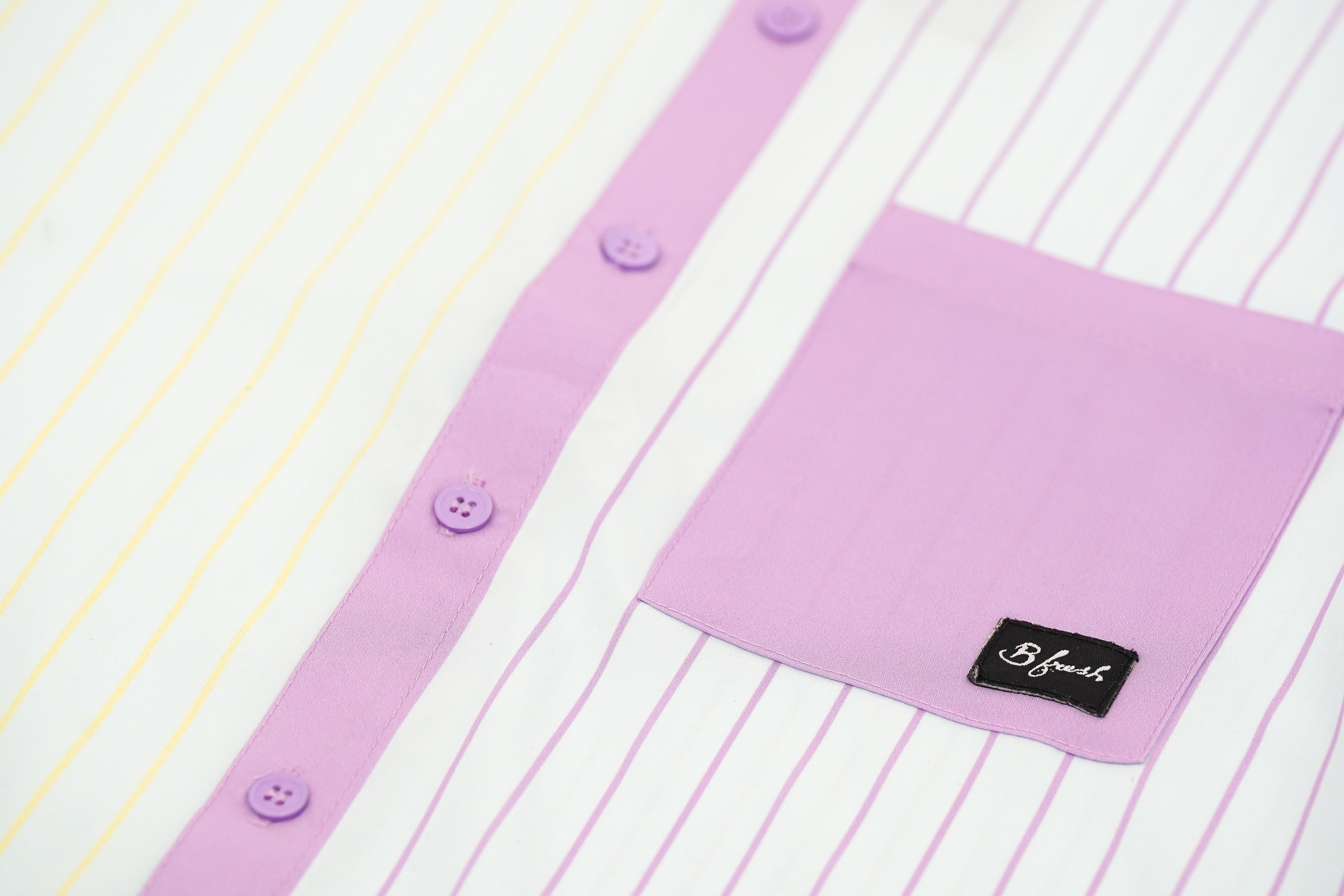 Close-up of a shirt with a purple collar and button details