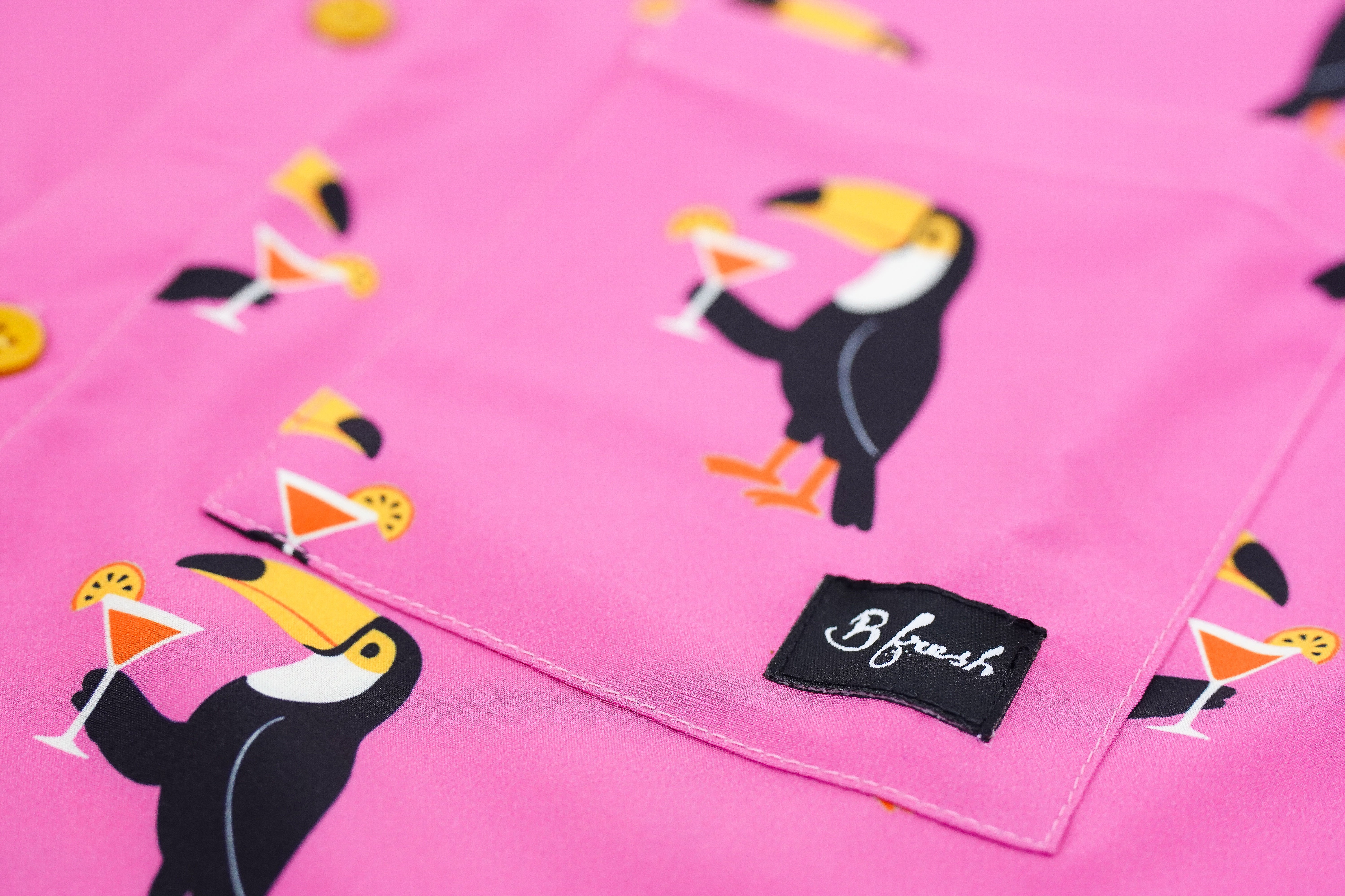 Pink fabric with toucan and cocktail pattern on pocket and B fresh label
