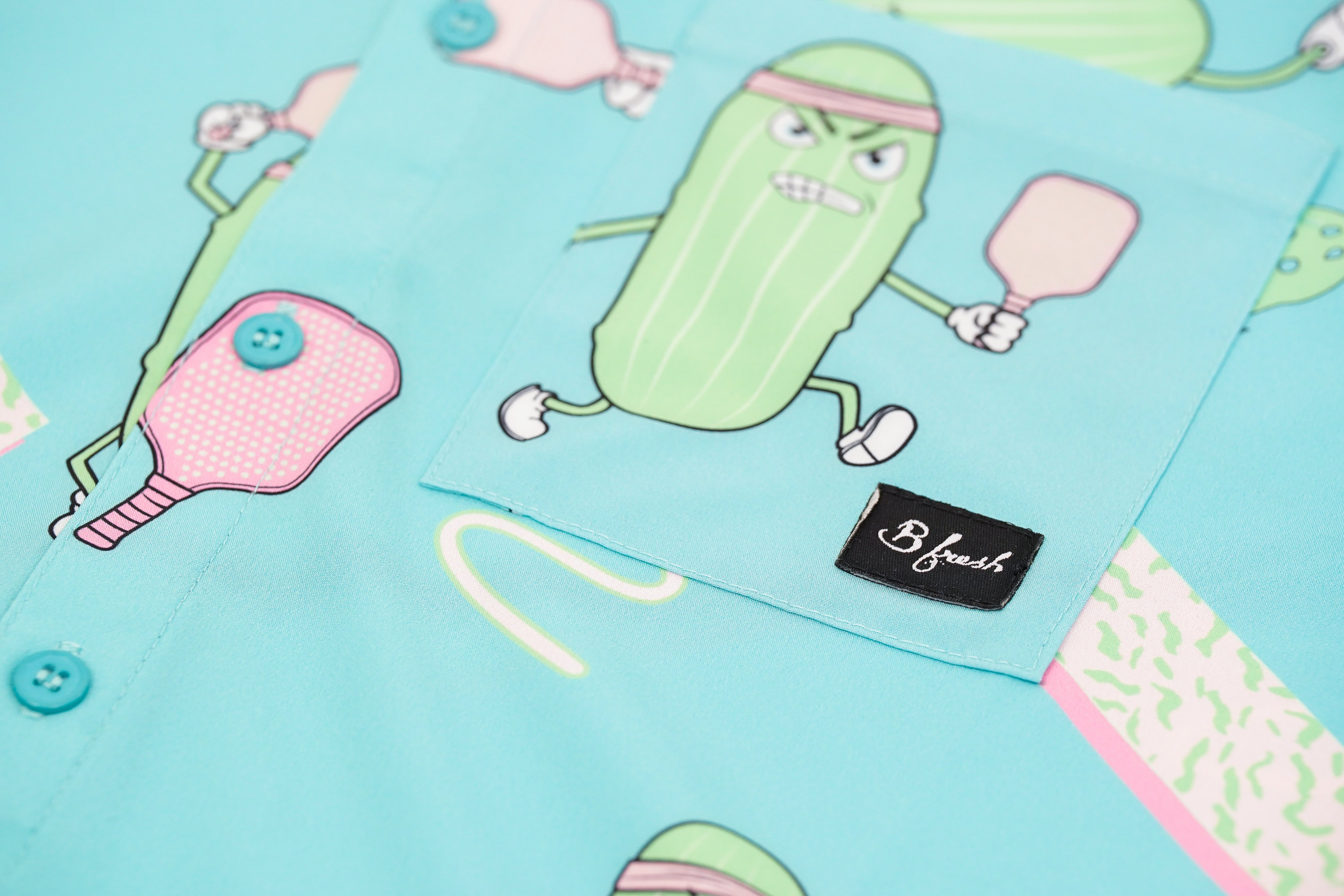 Fabric with pickle character design on a blue background, featuring the brand 'B. Fresh'.